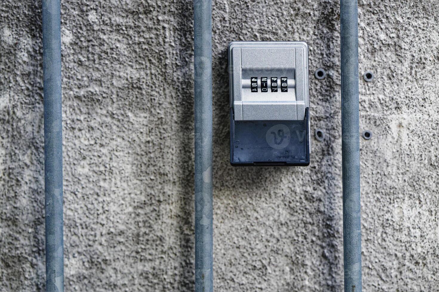 Compact key safe with numeric code embedded in concrete wall. photo