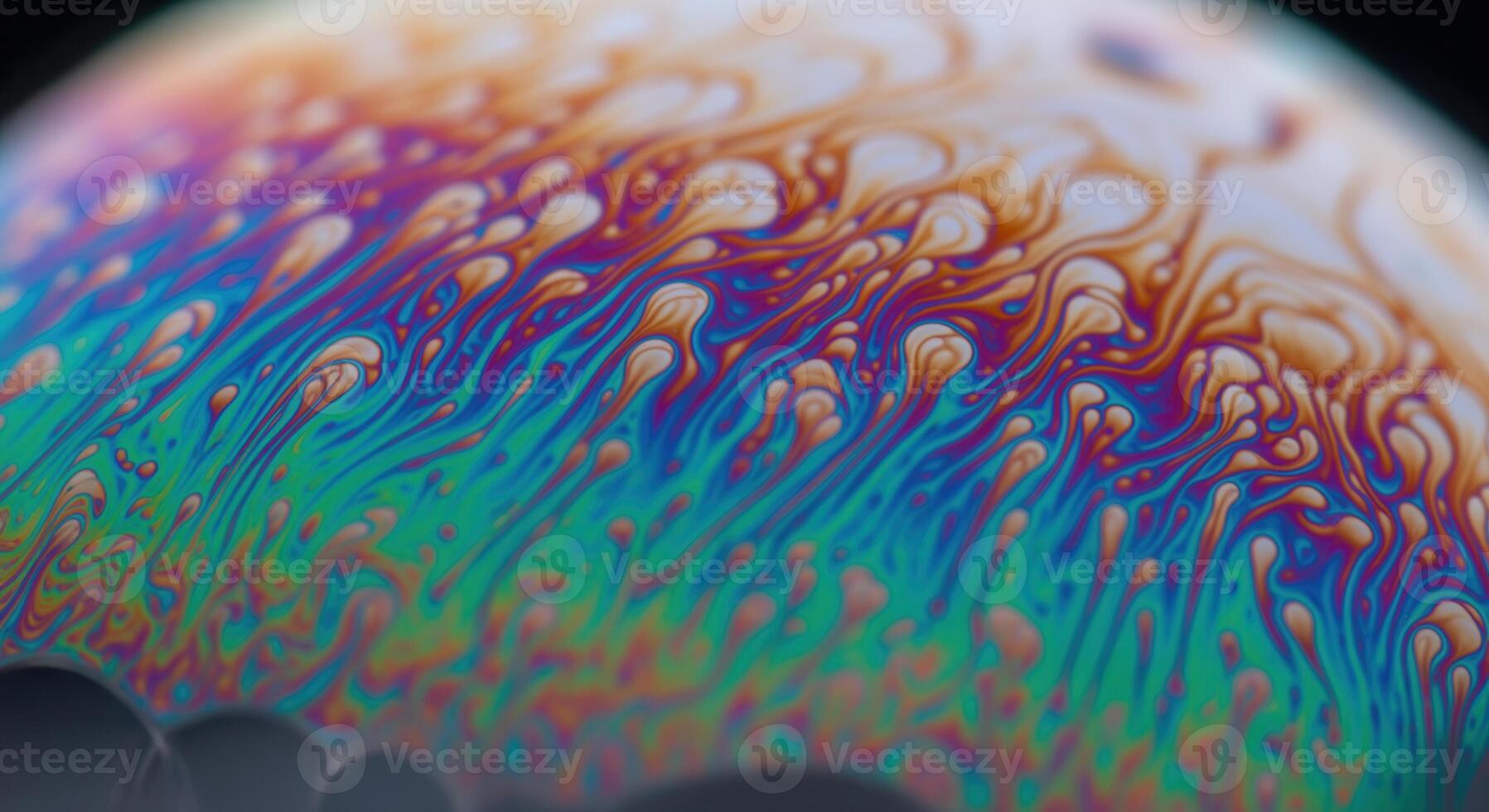 Macro close up of iridescent soap bubble surface with vibrant swirling colors and abstract patterns photo