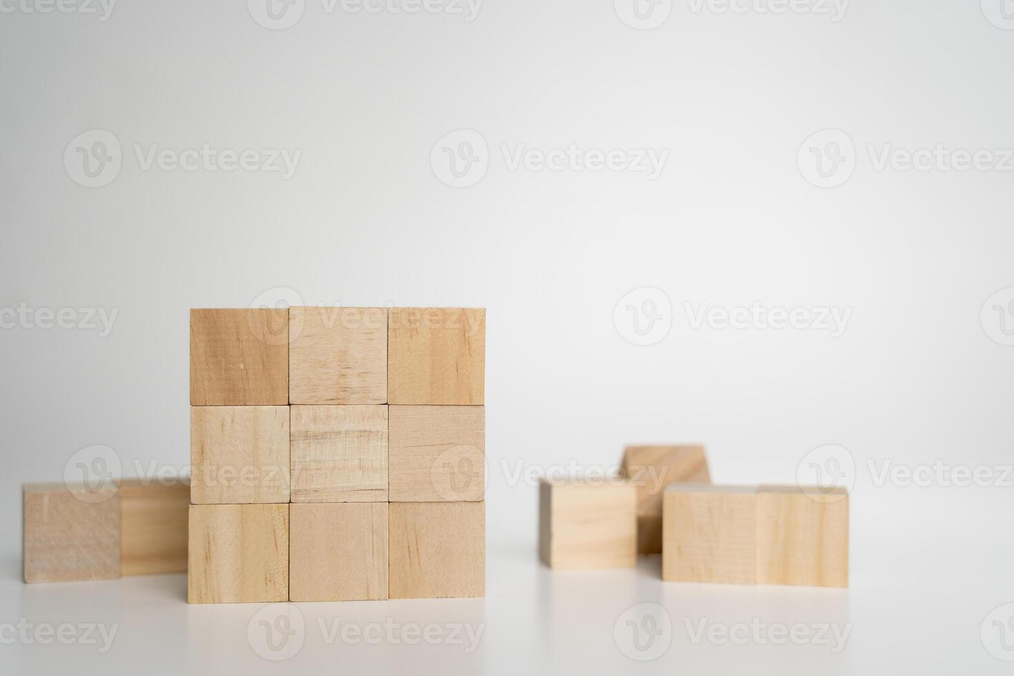 Wooden cubes arranged in solid square block on white background symbolizing structure, stability, order photo