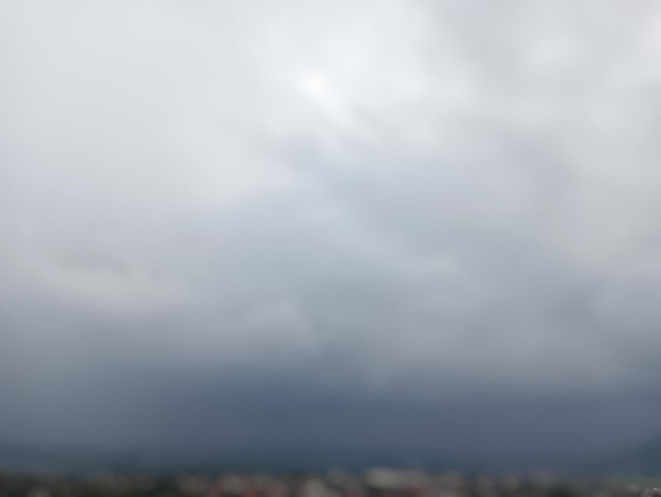 Out-of-focus image showing cloudy gray sky with soft overcast atmosphere and faint distant horizon background. photo