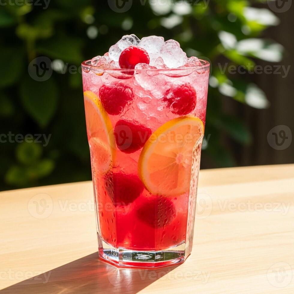 A glass of raspberry lemonade with ice and raspberries photo