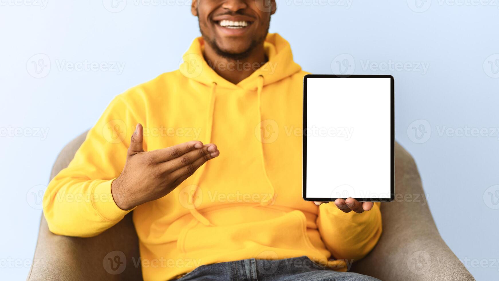Check This Out. Unrecognizable Black Man Showing Tablet Computer With Empty Screen Recommending Website Sitting On Gray Background. Mockup For Application Advertisement. Selective Focus, Panorama photo