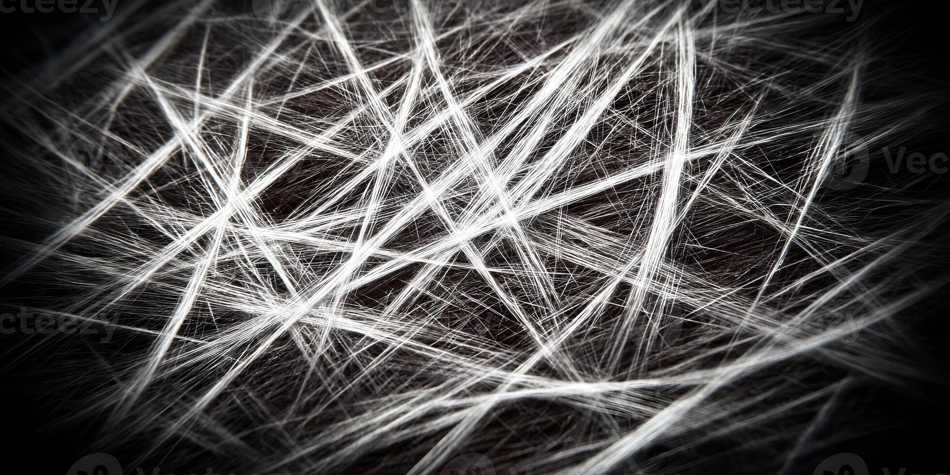 Luminous white lines form a dynamic abstract tangled pattern on a dark background creating a textured visual effect photo