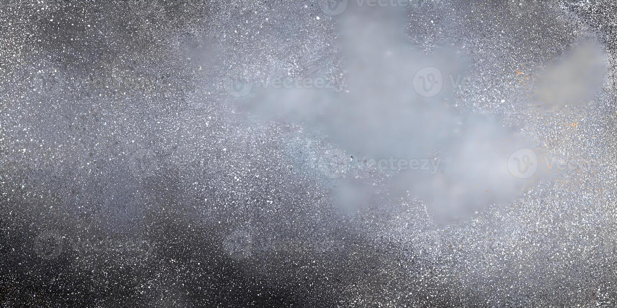 A dark charcoal gray surface is covered with a fine speckle texture creating a grunge background photo