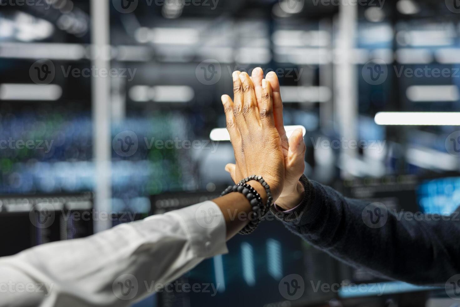 Close up of data center employees doing high five after upgrade systems using AI tech. IT workers celebrating achievement in server room, finishing deep learning checkup on hardware rigs photo