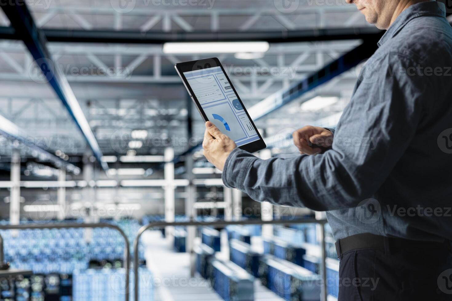 Close up of data center admin checking infrastructure diagnostics interface on tablet screen. IT professional in high tech server room examining data charts during system audit photo