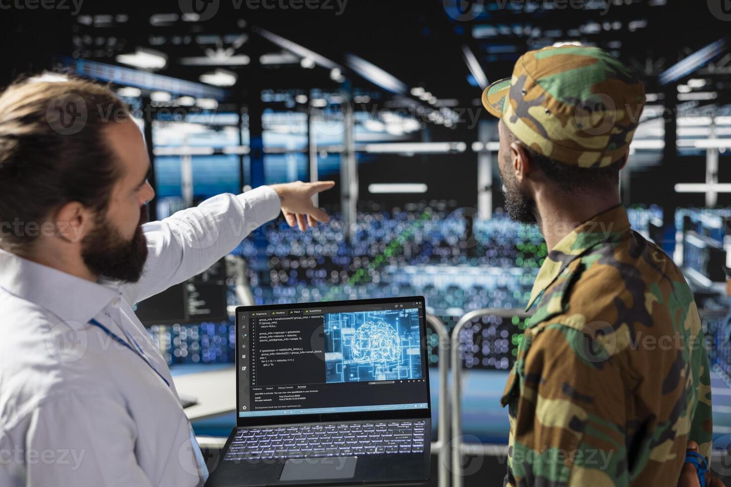 African american army technician uses neural network for defense systems, working with an engineer in server farm. Drone operators in military data center doing live drone tracking on laptop. photo