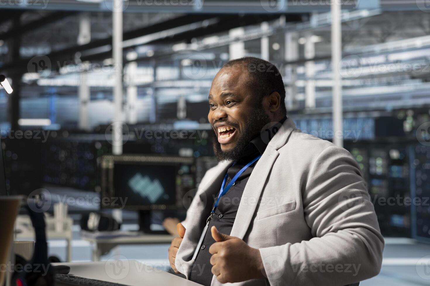 Overjoyed programmer in server hub satisfied by improved system efficiency metrics. Ecstatic African american man working in data center pleased by enhanced network infrastructure performance photo