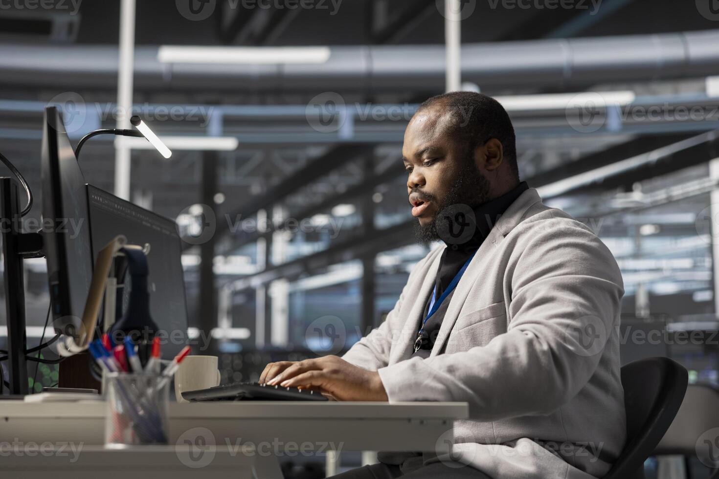 Data center system administrator running diagnostic scripts, examining infrastructure. Man working in server hub using PC to evaluate performance metrics, running tests to maintain system stability photo