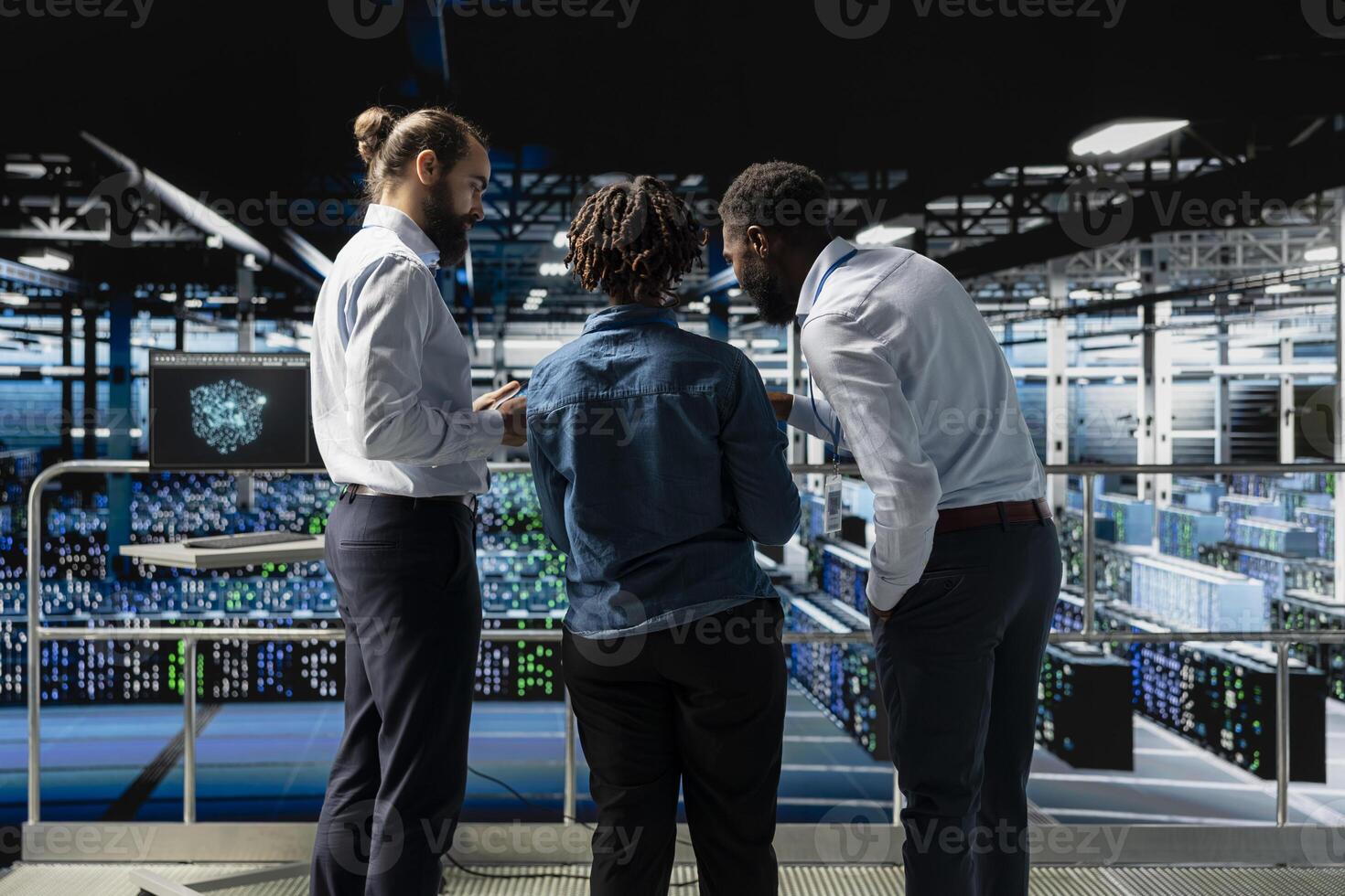 Data center system administrators using laptop to review AI LLM visualization. African american team of engineers use devices to analyze neural network outputs, ensuring stable operations. photo