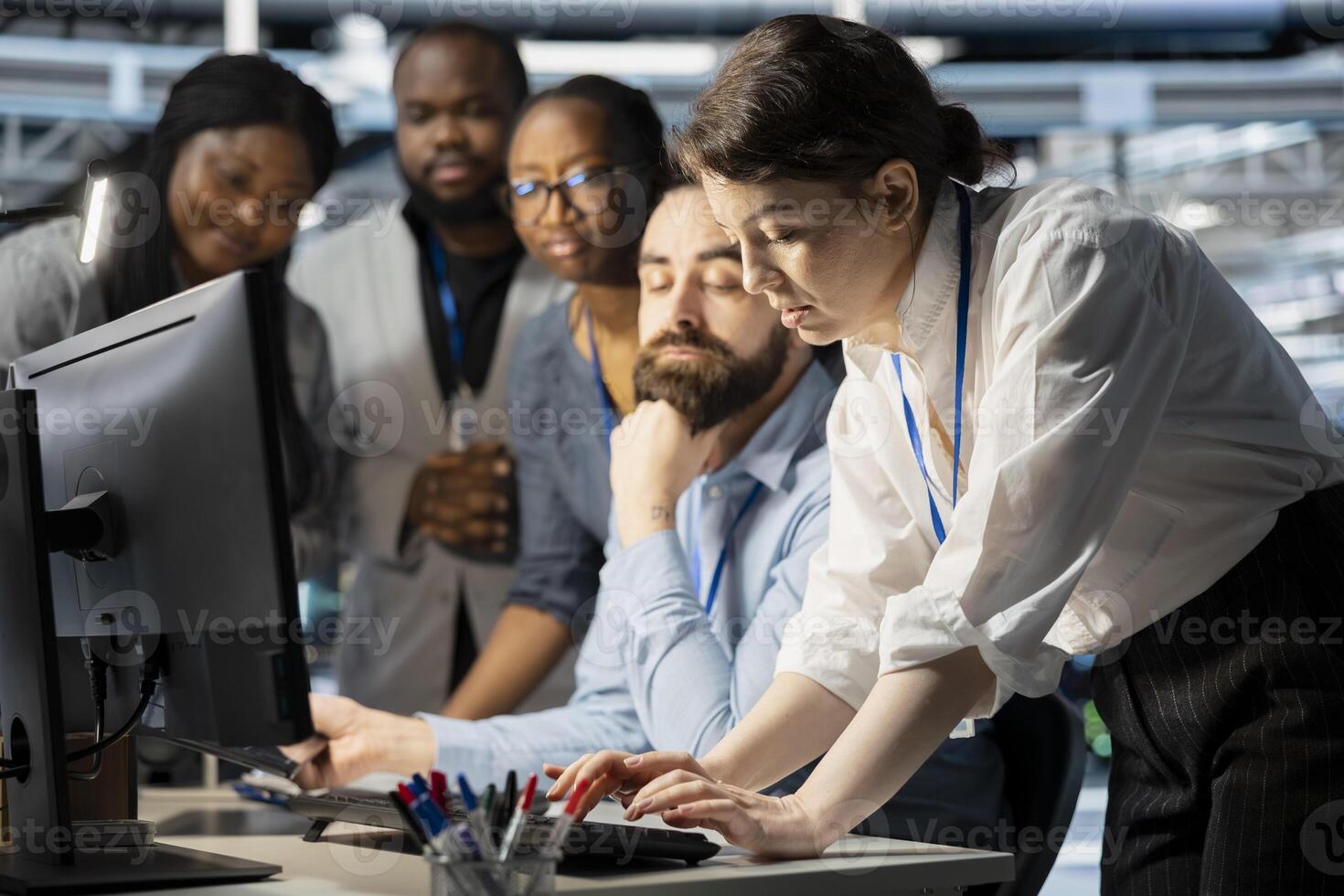Team of programmers in data center cooperating to update storage arrays software, configuring network virtualization. Server farm coworkers doing brainstorming, using computer to verify settings photo
