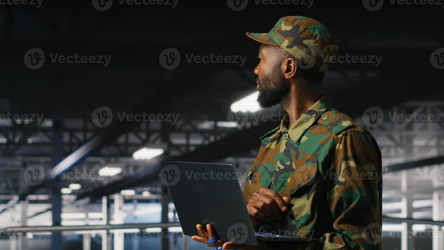 Army technician in command center server room using laptop to install and maintain IT systems. Military data center admin overseeing computer networks and information systems photo