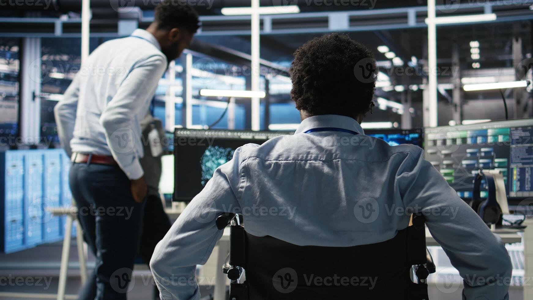 Data center programmer in wheelchair entering office uses AI node tree program to minimize system downtime. Server room IT expert in disability uses machine learning visual programming tool, camera A photo