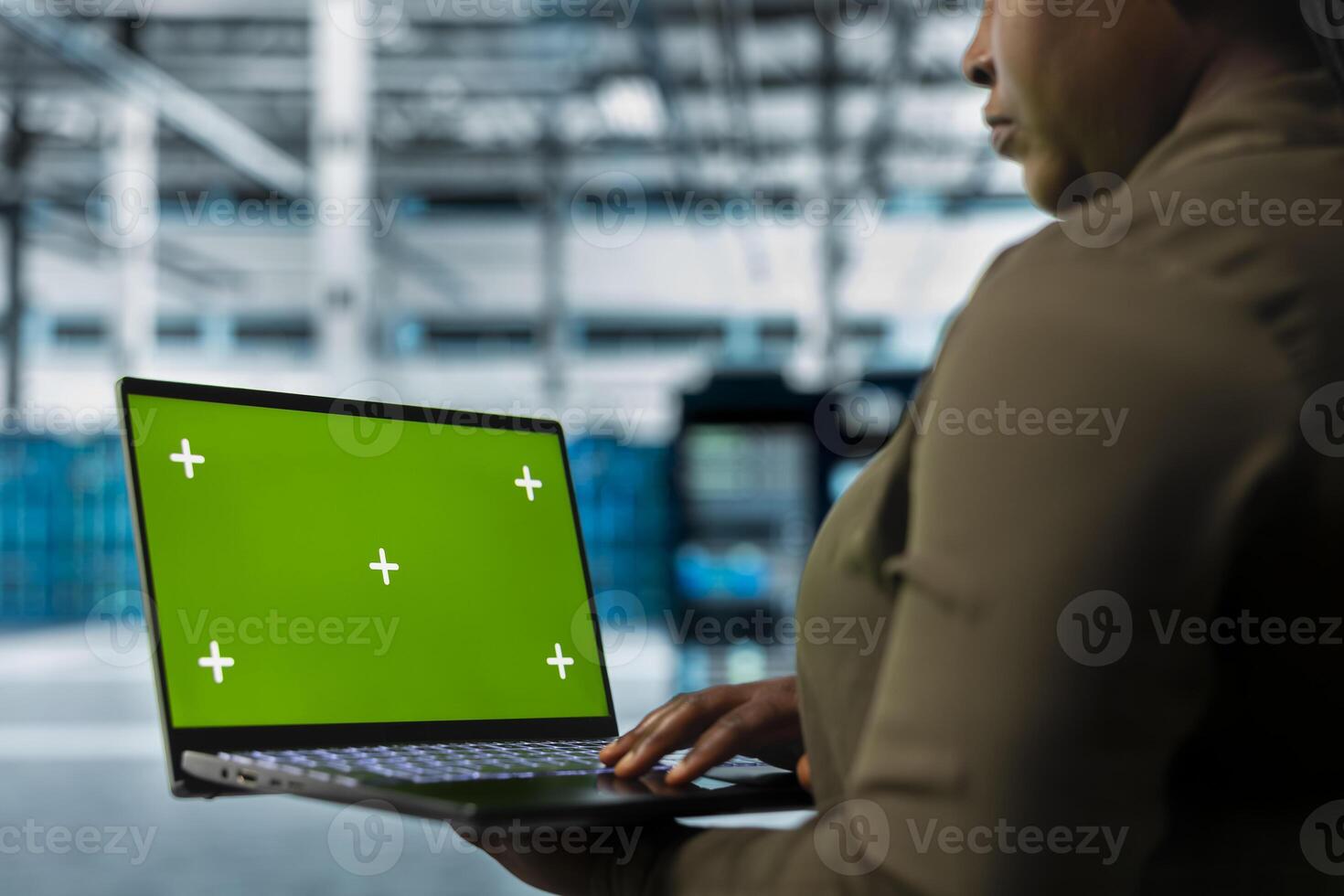 Technician uses isolated screen laptop to implement security measures, fortifying data center against cyber threats. Server hub manager uses mockup notebook to detect threats, defending systems photo