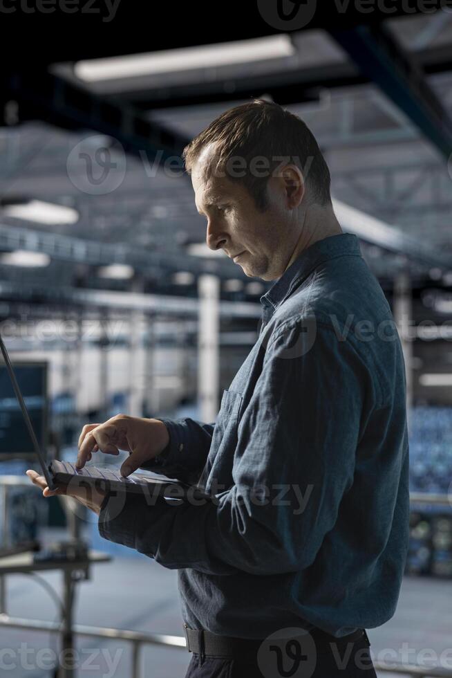 Admin on data center industrial platform analyzing infrastructure performance, monitoring potential failures. Server farm employee doing job tasks, debugging software issues photo