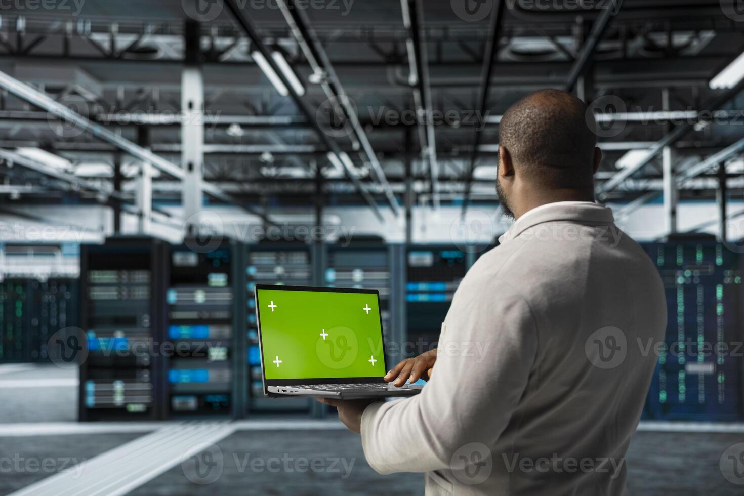 Data center engineer using green screen notebook in data center, deploying tools to reduce downtime. Server hub developer using mockup laptop, managing software updates for system stability photo