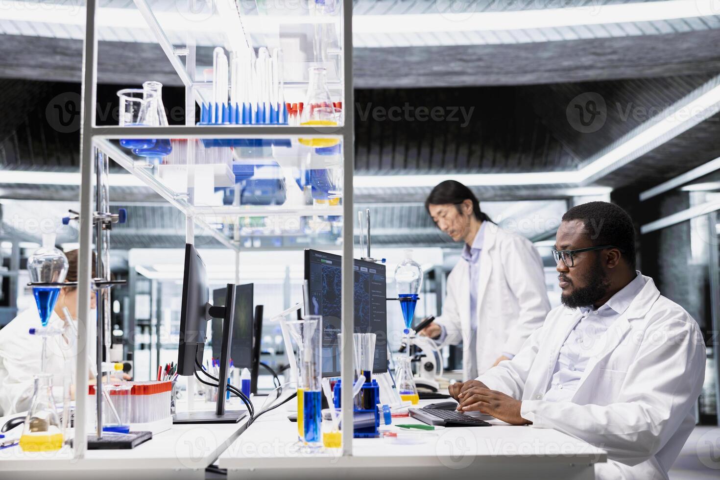 Molecular biologist uses computer program displaying DNA data analysis interface in laboratory. African american man using bioinformatics genomics software on PC in sterile lab environment photo