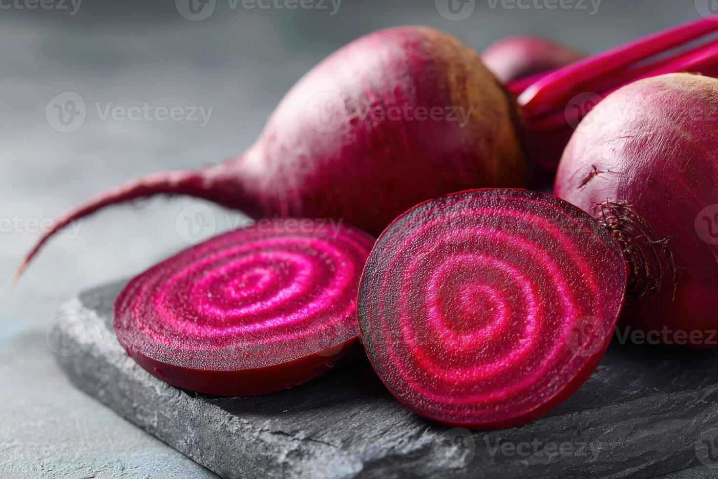 Sliced beetroot showcasing vibrant radial patterns on a dark slate surface, highlighting its rich color and texture, perfect for culinary or health-related themes with copy space photo