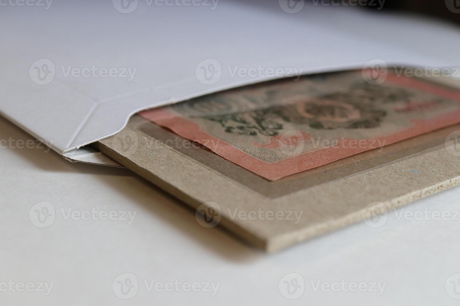 An envelope partially opened, revealing a decorative piece of paper or art inside, with a focus on textures and colors photo