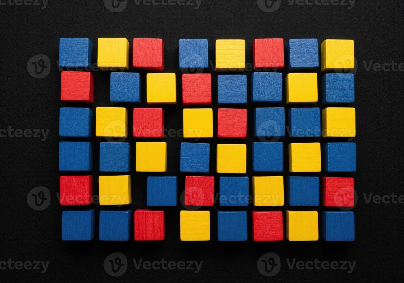 Vibrant primary colored wooden blocks arranged in a grid pattern on a dark surface photo