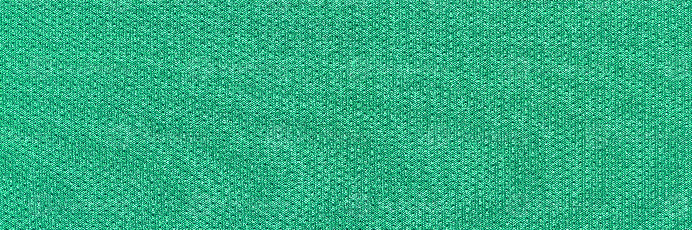 Green textured fabric pattern with diamond shapes in a close-up view showing detailed weave design. photo