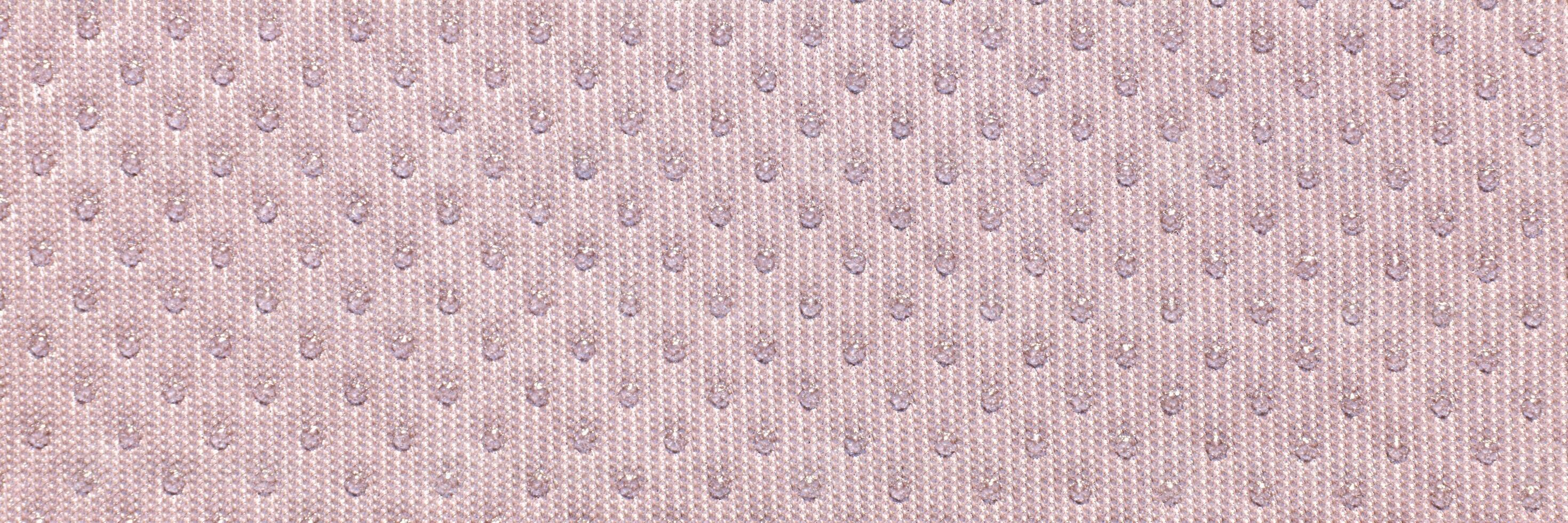 Textured beige fabric close-up with subtle pattern of small dots creating elegant surface design. photo