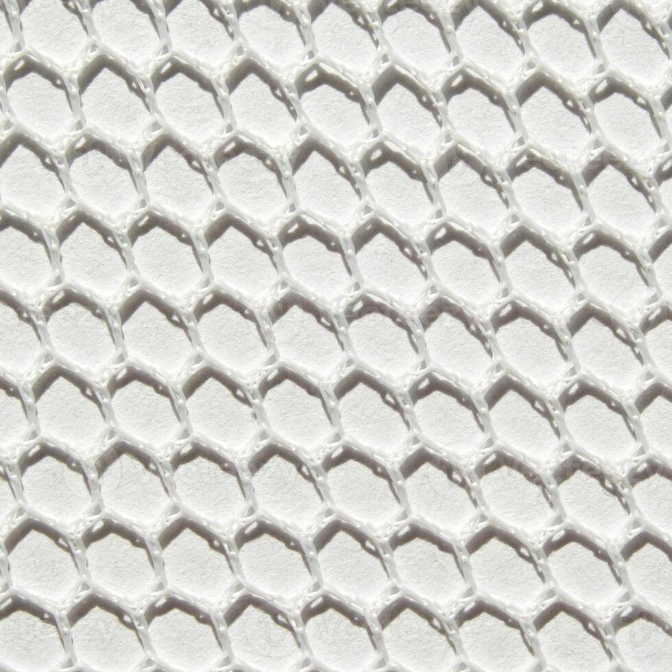 Close-up of textured white honeycomb pattern background with geometric hexagonal design. photo