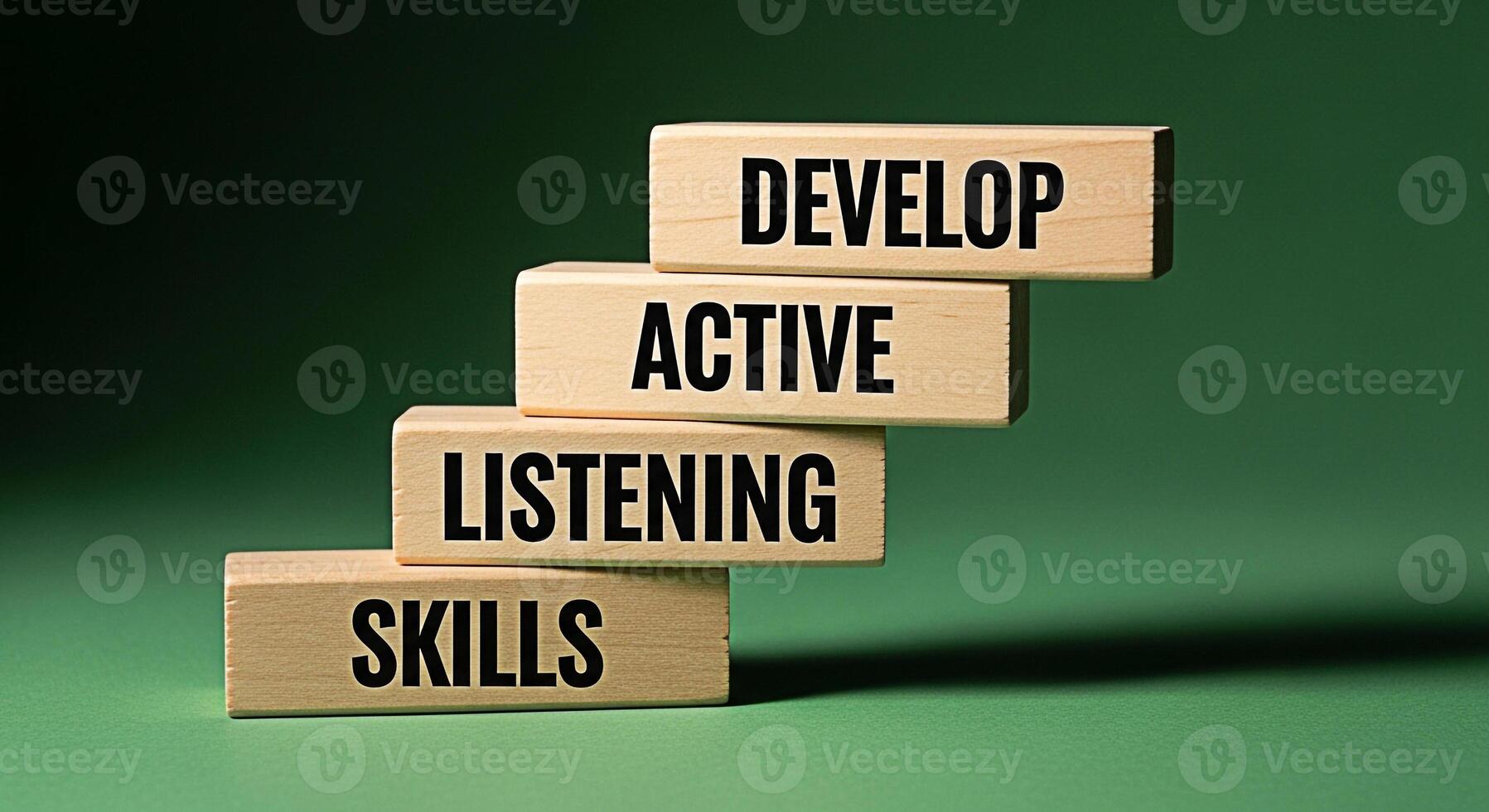 Wooden blocks stacked to represent steps each block displaying a key skill Develop Active Listening Skills set against a green background symbolizing growth and improvement in communication photo