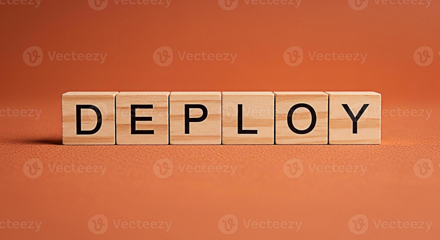 Wooden blocks spelling DEPLOY on a textured orange surface representing software deployment in a simple studio setting conveying a sense of readiness and implementation for business and technology con photo