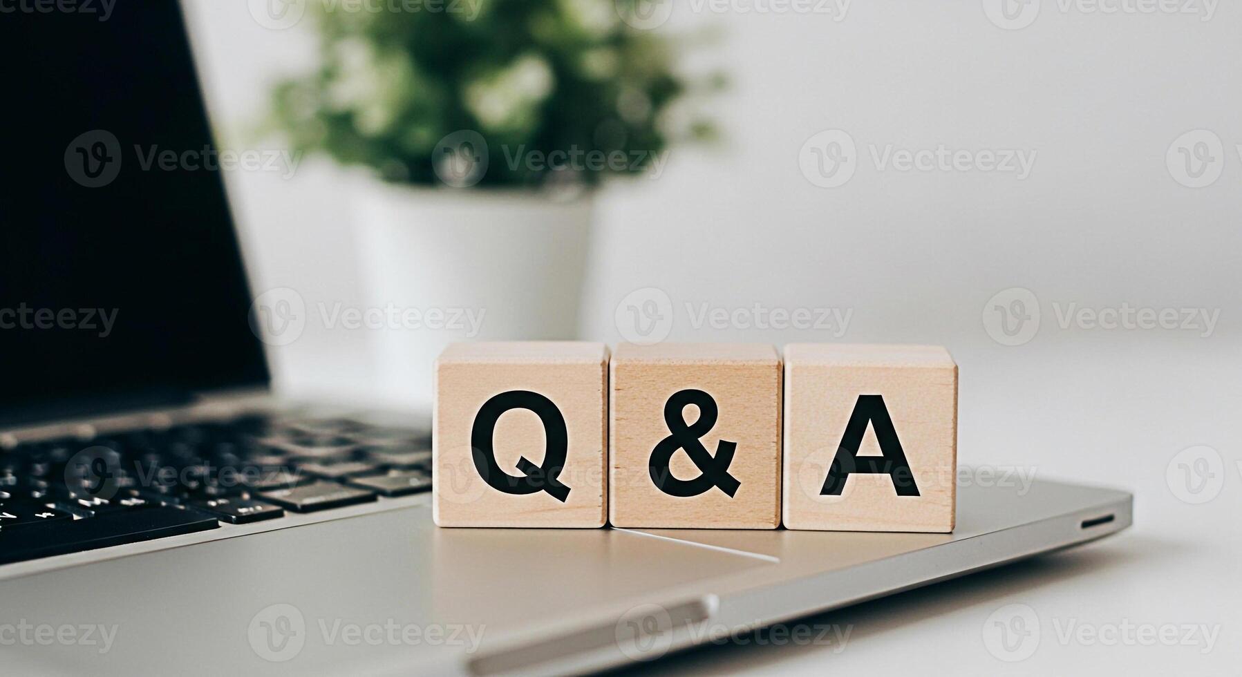 Wooden blocks displaying Q A on a laptop in a bright modern office symbolizing knowledge information and the importance of asking questions for learning and problemsolving in a digital environment photo
