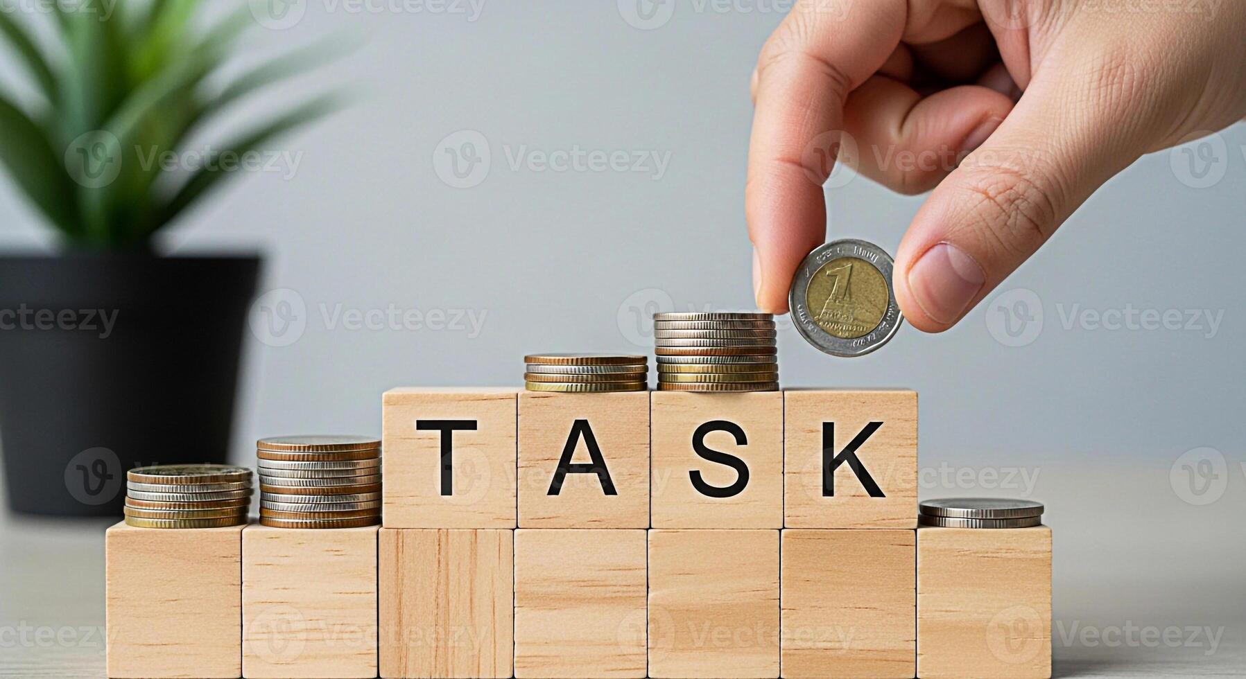 Human hand placing a coin on a stack of coins atop wooden blocks spelling TASK on a neutraltoned table symbolizing financial goals investment growth and the successful completion of business objective photo