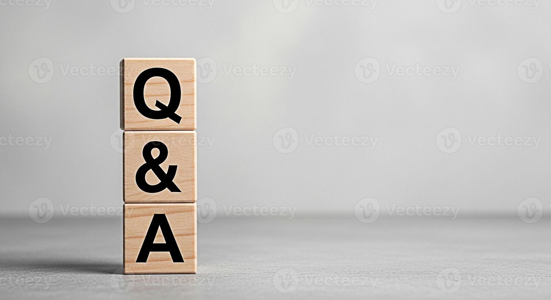 Wooden blocks stacked vertically displaying QA on a gray surface representing questions and answers in a simple and direct manner ideal for educational or informational content with a clean and minima photo