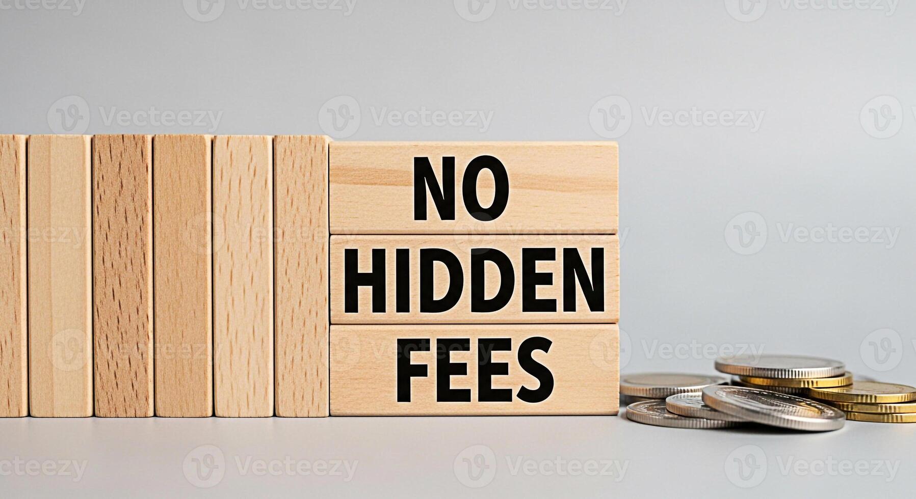 Wooden blocks displaying No Hidden Fees next to a pile of coins on a neutral surface representing transparency and trust in financial transactions and promoting a sense of security and straightforward photo