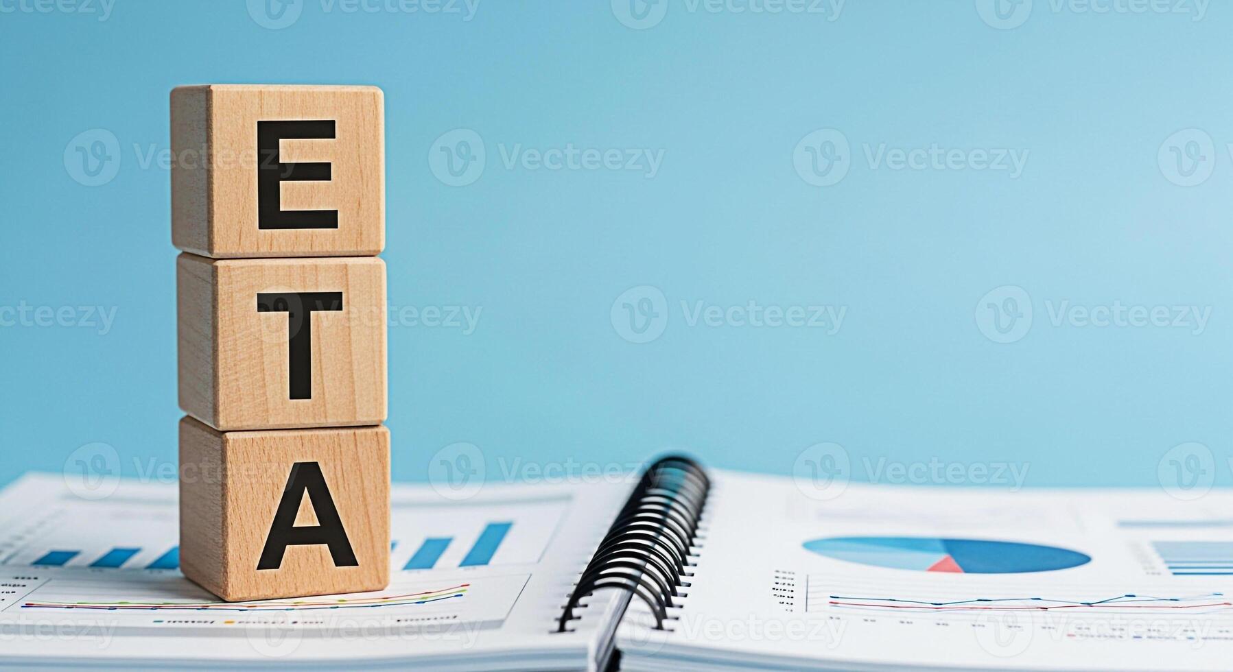 Wooden blocks displaying ETA sitting atop a business report with charts and graphs symbolizing estimated time of arrival and project planning in a corporate setting conveying a sense of organization a photo