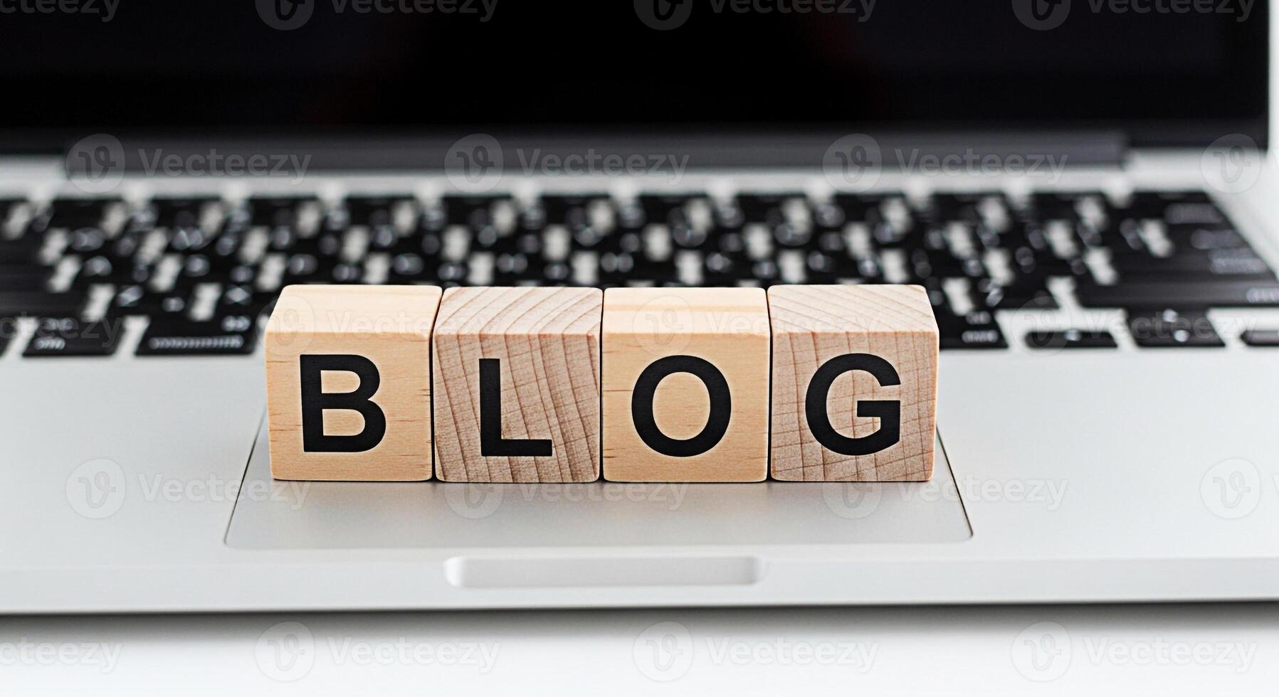 Wooden blocks spelling BLOG resting on a modern laptop keyboard in a bright minimalist workspace symbolizing online content creation digital marketing and the power of blogging for business and person photo