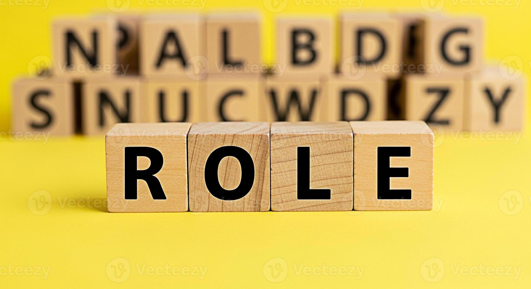 Wooden blocks spelling out ROLE on a bright yellow surface representing the concept of responsibilities and expectations in a playful and educational environment fostering learning and development photo