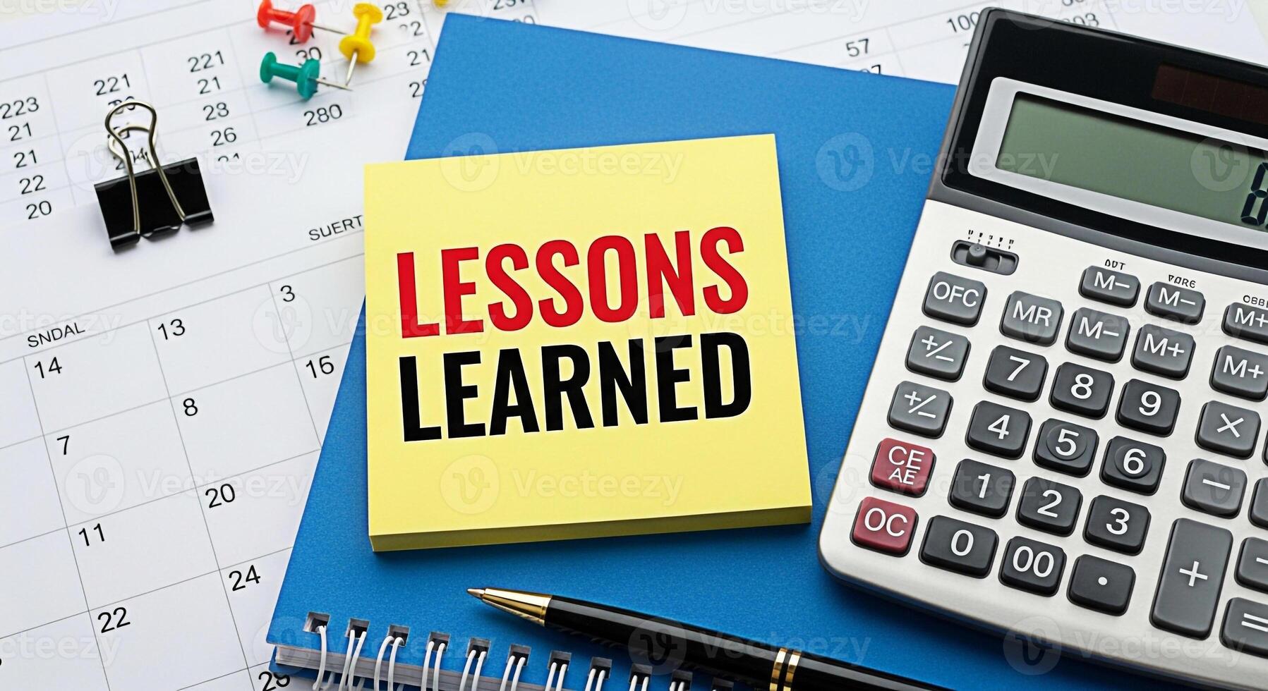 Analyzing lessons learned on a desk with calendar calculator pen and notepad reflecting on past experiences for future improvement and strategic planning in a professional office setting photo