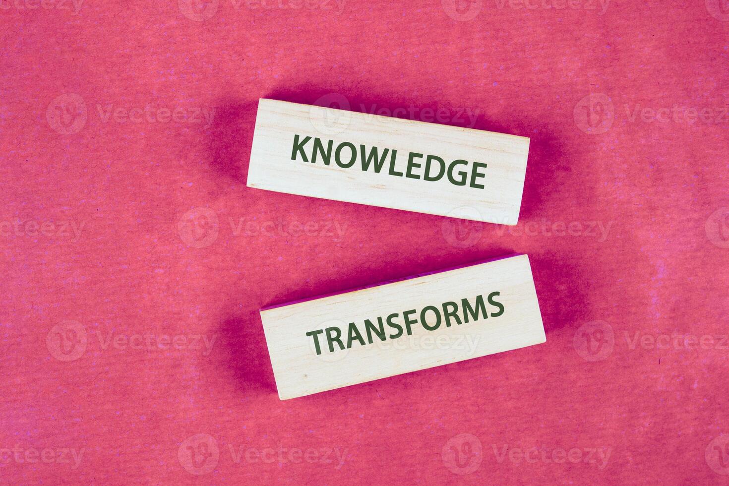 Knowledge learning innovation concept. KNOWLEDGE TRANSFORMS words assembled from blocks on a crimson background, top view photo