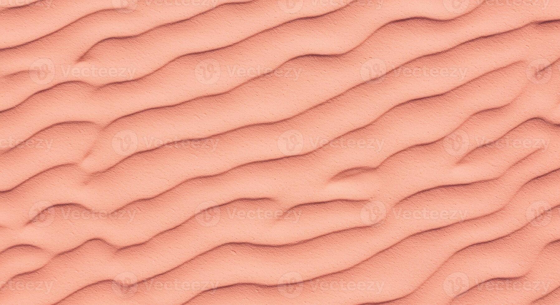 The wavy patterns of desert sand are visible in the high angle shot as a natural beige texture with rolling curves creating abstract art. photo