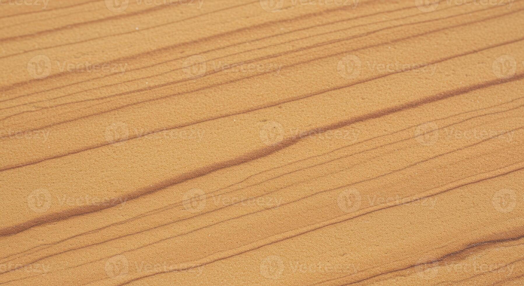 A close up shows the fine lines and subtle textures of wind blown sand creating beautiful patterns in a desert landscape environment. photo