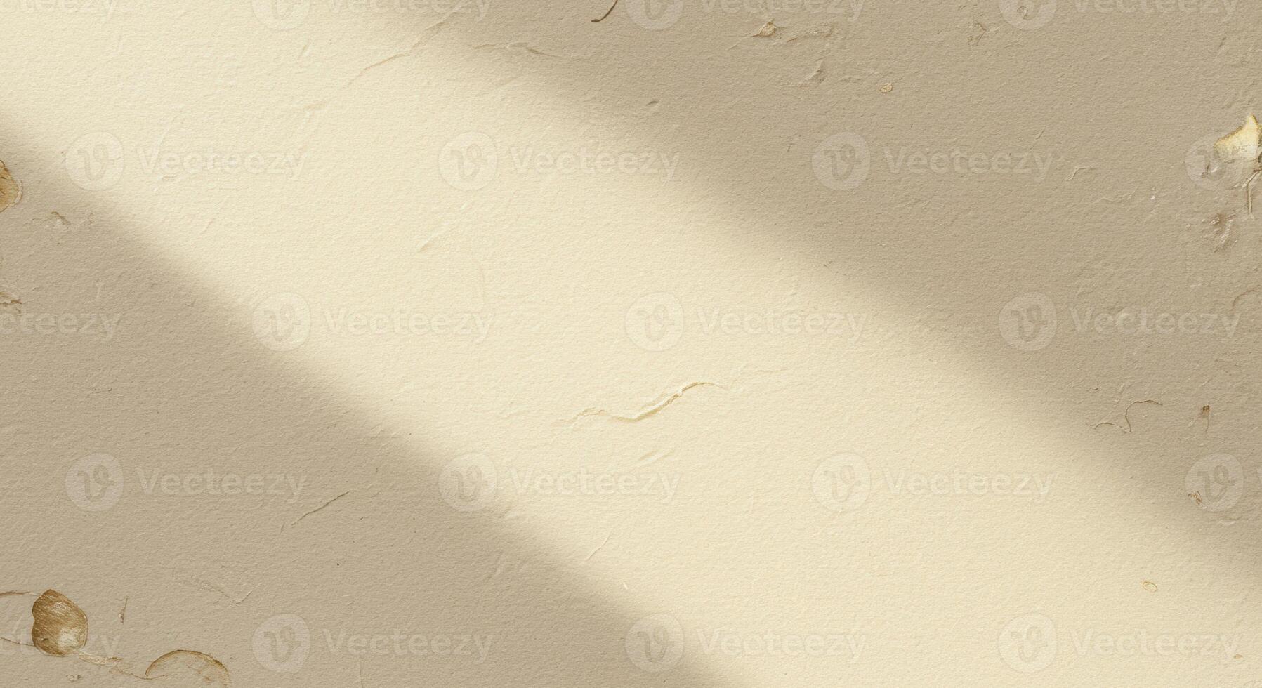 A diagonally cast light illuminates a textured cream colored wall adding depth and creating a subtle contrast in brightness across the surface. photo