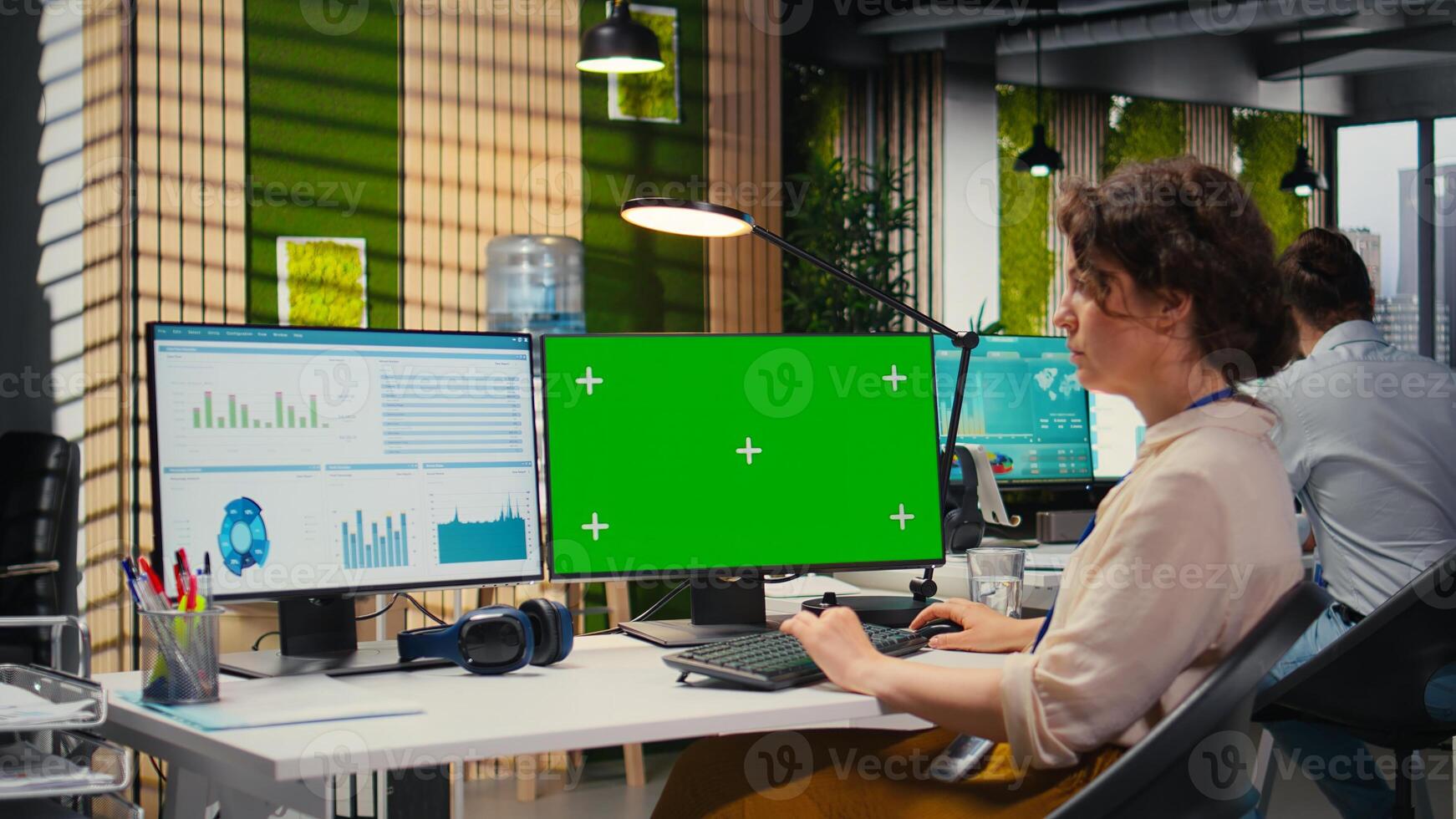 Executive assistant analyzing KPI metrics on computer monitor with mockup, handling task completion with infographics and data analytics on pc. Businesswoman seeing insights. photo