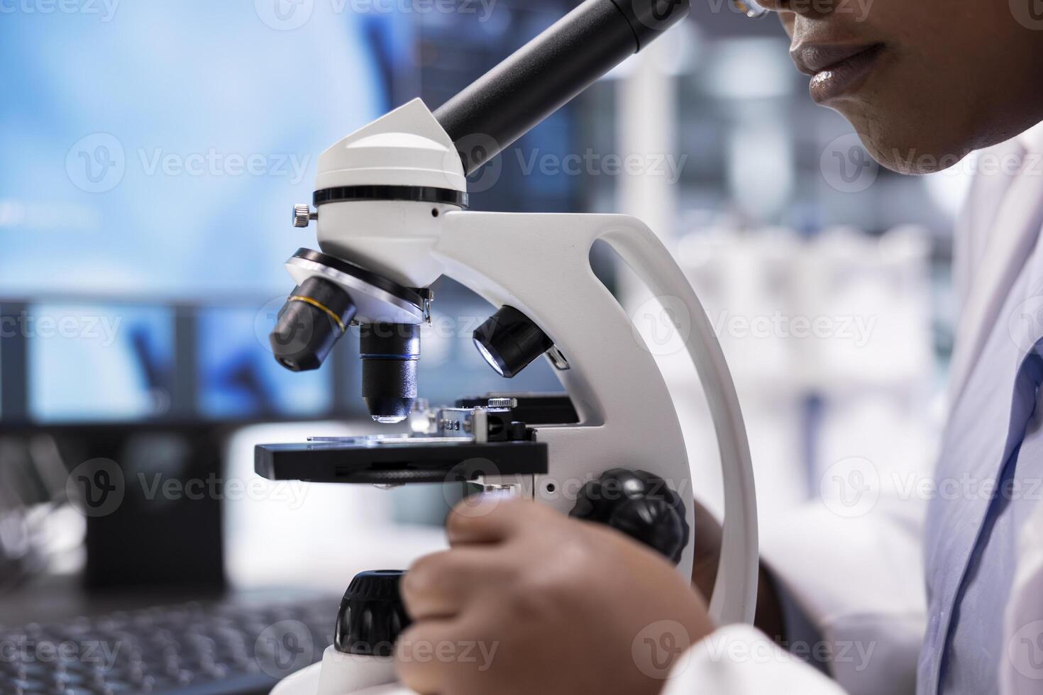Microscope close up of specimen tray in lab studied by expert. Optical instrument, lens system and magnifying glass support cellular testing and biotechnology for healthcare. Bio science. photo