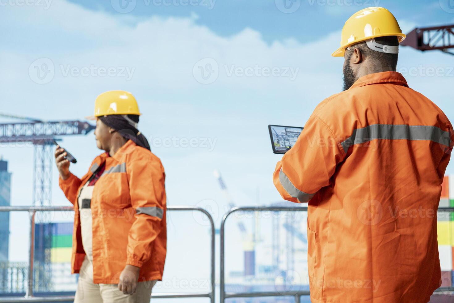 Offshore platform expert tracking oil production efficiency using tablet app. Drilling rig coworkers use device program to check equipment sensor readings, doing maintenance photo
