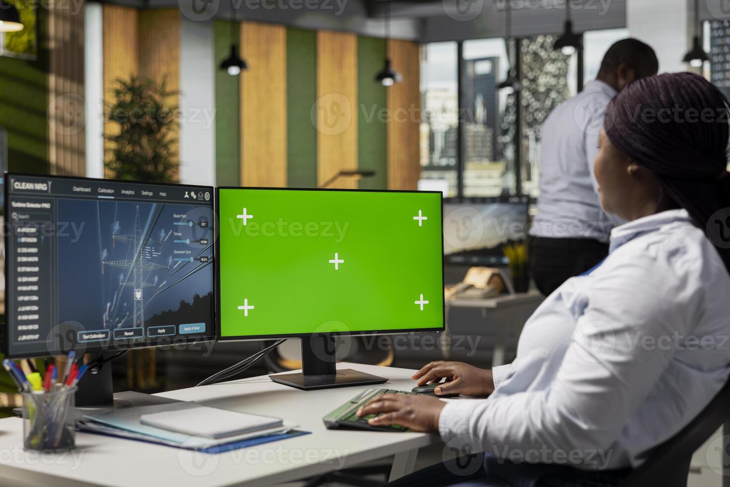 Engineer reviews electrical grid data on green screen PC to identify energy audit findings. Worker looks at transmission tower efficiency metrics analytics dashboard on mockup computer photo