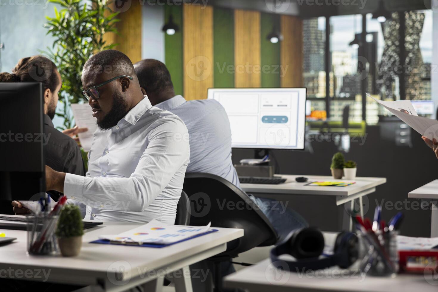 Diverse employees business specialists collaborating in modern office, focusing on project planning, performance metrics and report sharing. Business people review data for forecasting. photo