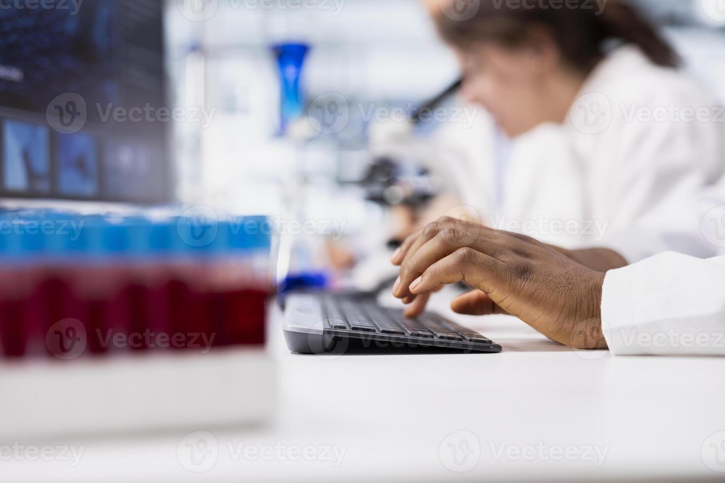 Close up of laboratory researcher using computer software to process DNA patient data for clinical research. Lab specialist typing on PC keyboard, doing genetic analysis diagnostics photo