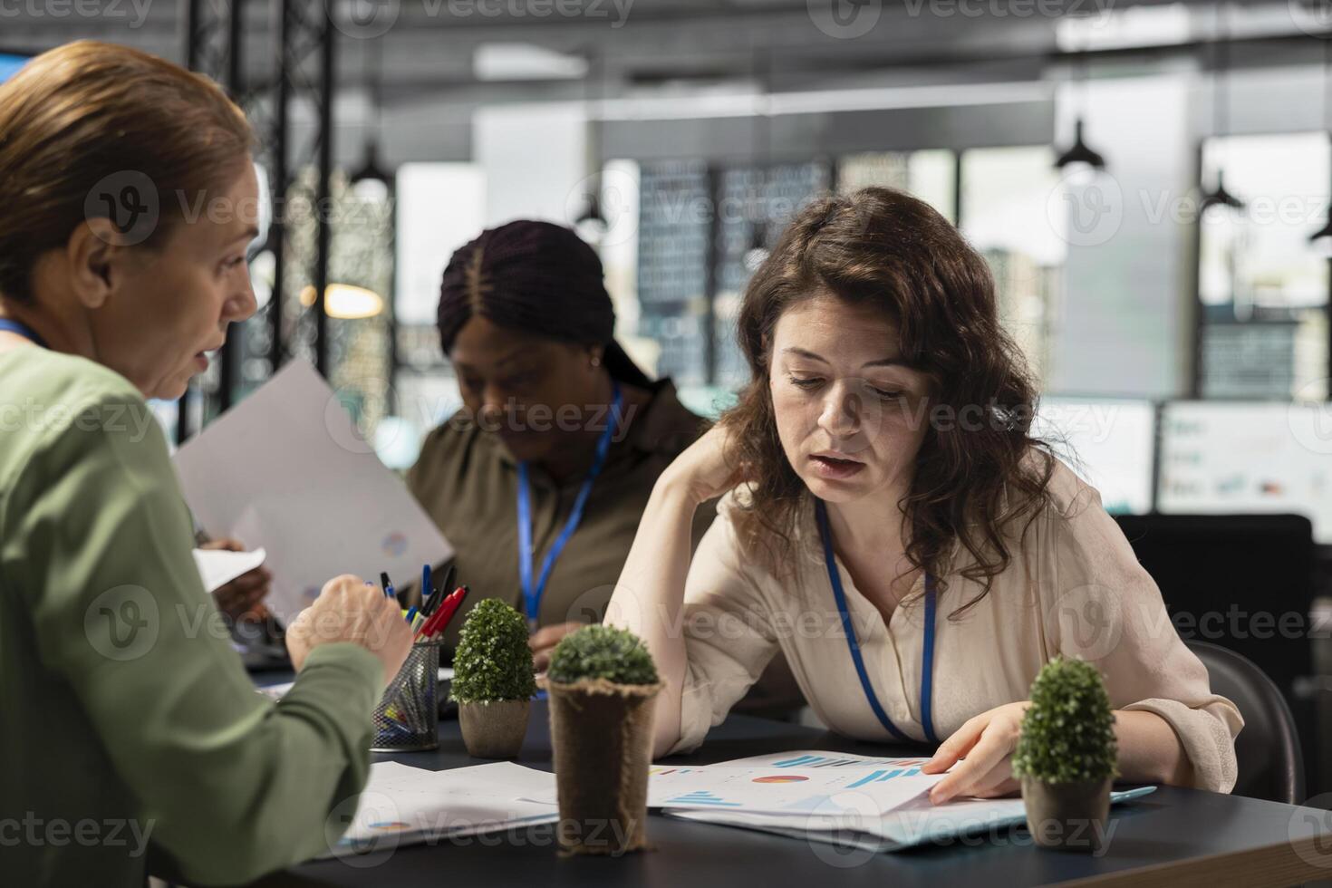 Focused team of managers reviewing data insights on papers, collaborating in a modern boardroom session. Discussing progress indicators and setting the foundation for a corporate success story. photo
