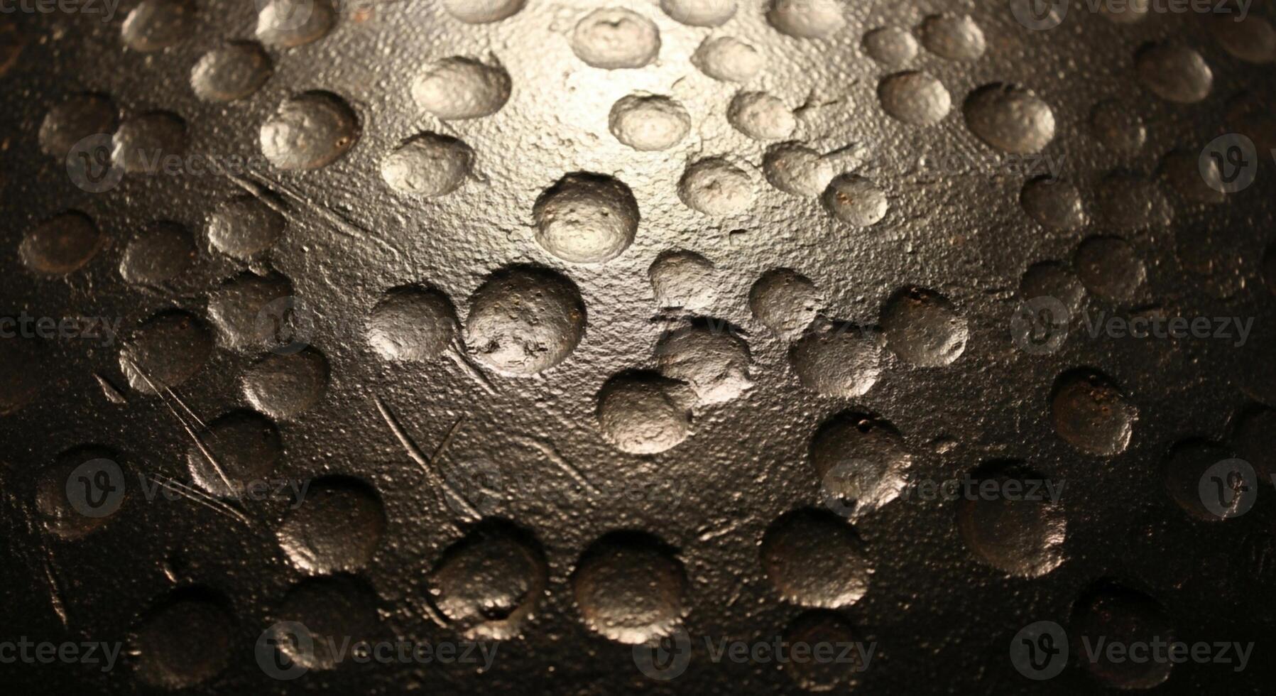 Close up abstract view of a golf ball s dimples with a textured surface and dramatic lighting creating shadows photo