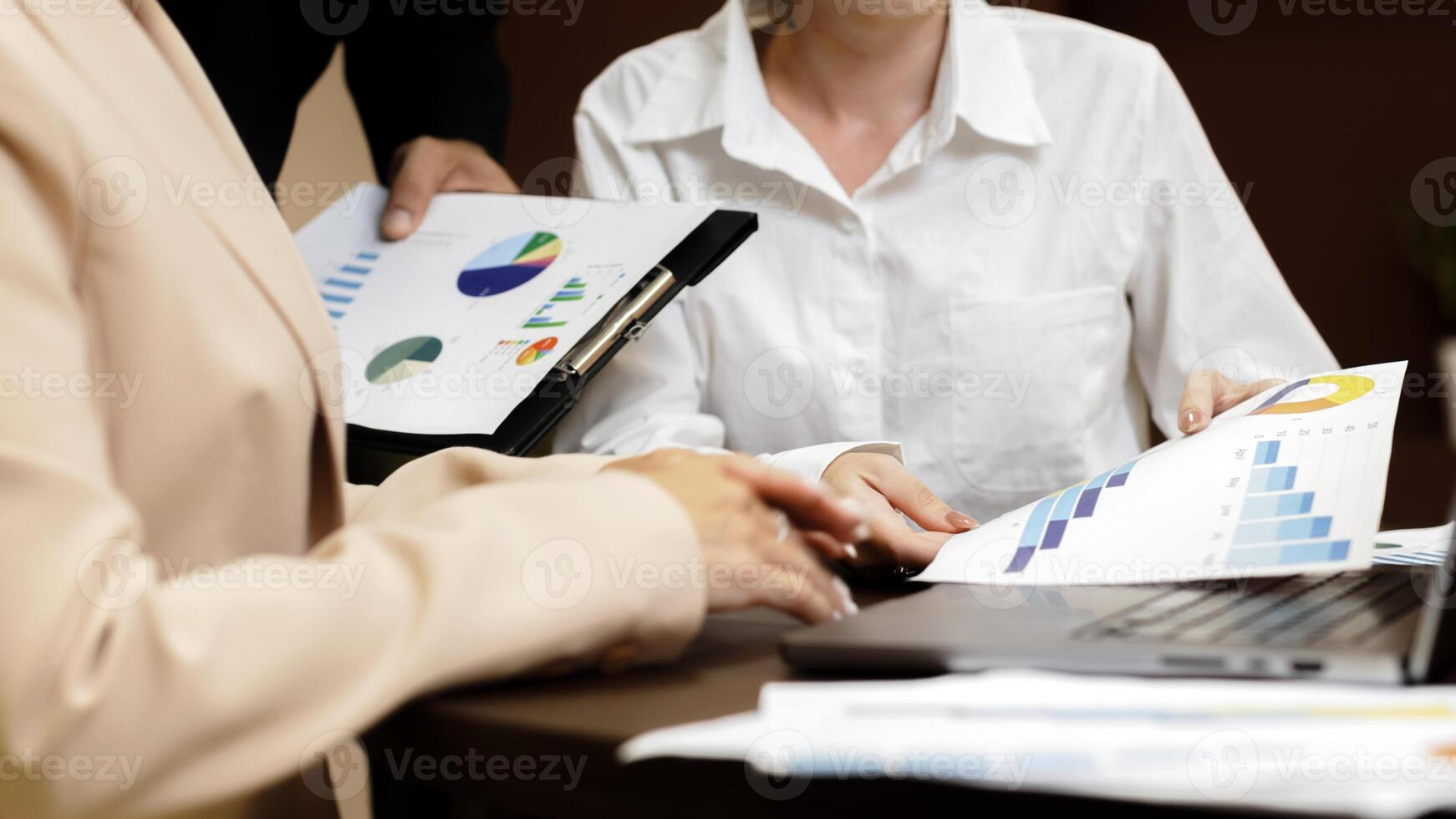 Business professionals collaborating on project analysis in a contemporary workspace, using digital and printed resources. photo